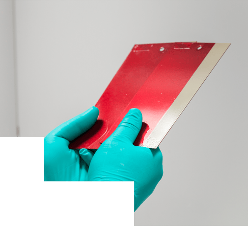 Hands holding two red color panels to color match