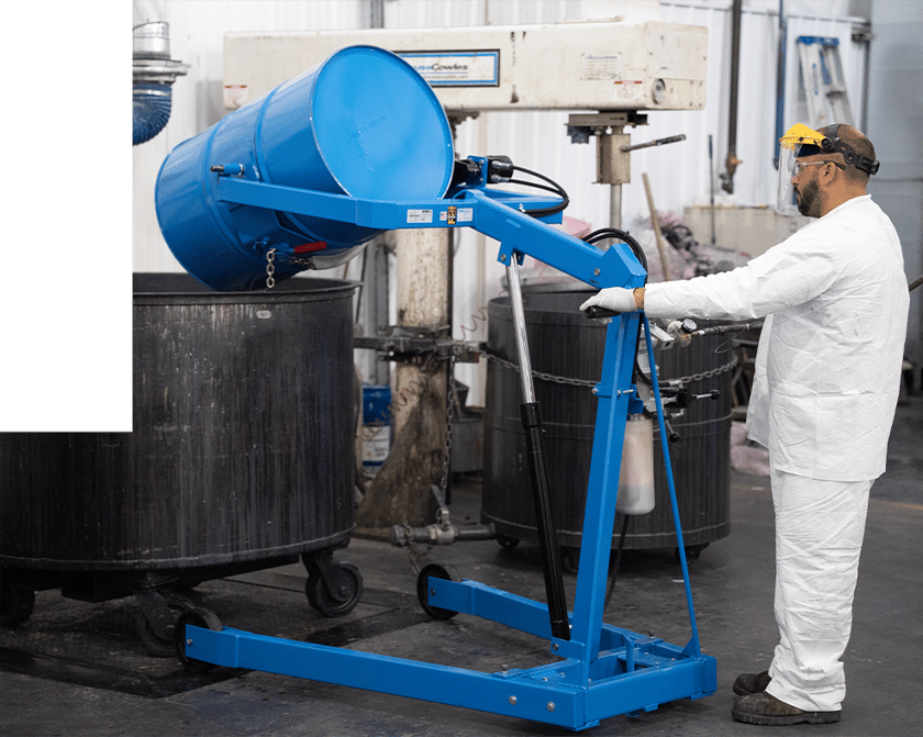 Man pouring paint from a drum to a vat