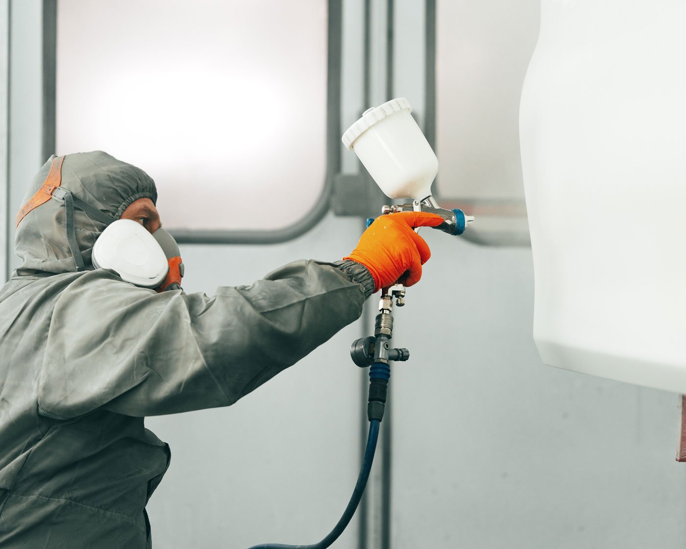 person applying paint to vehicle frame