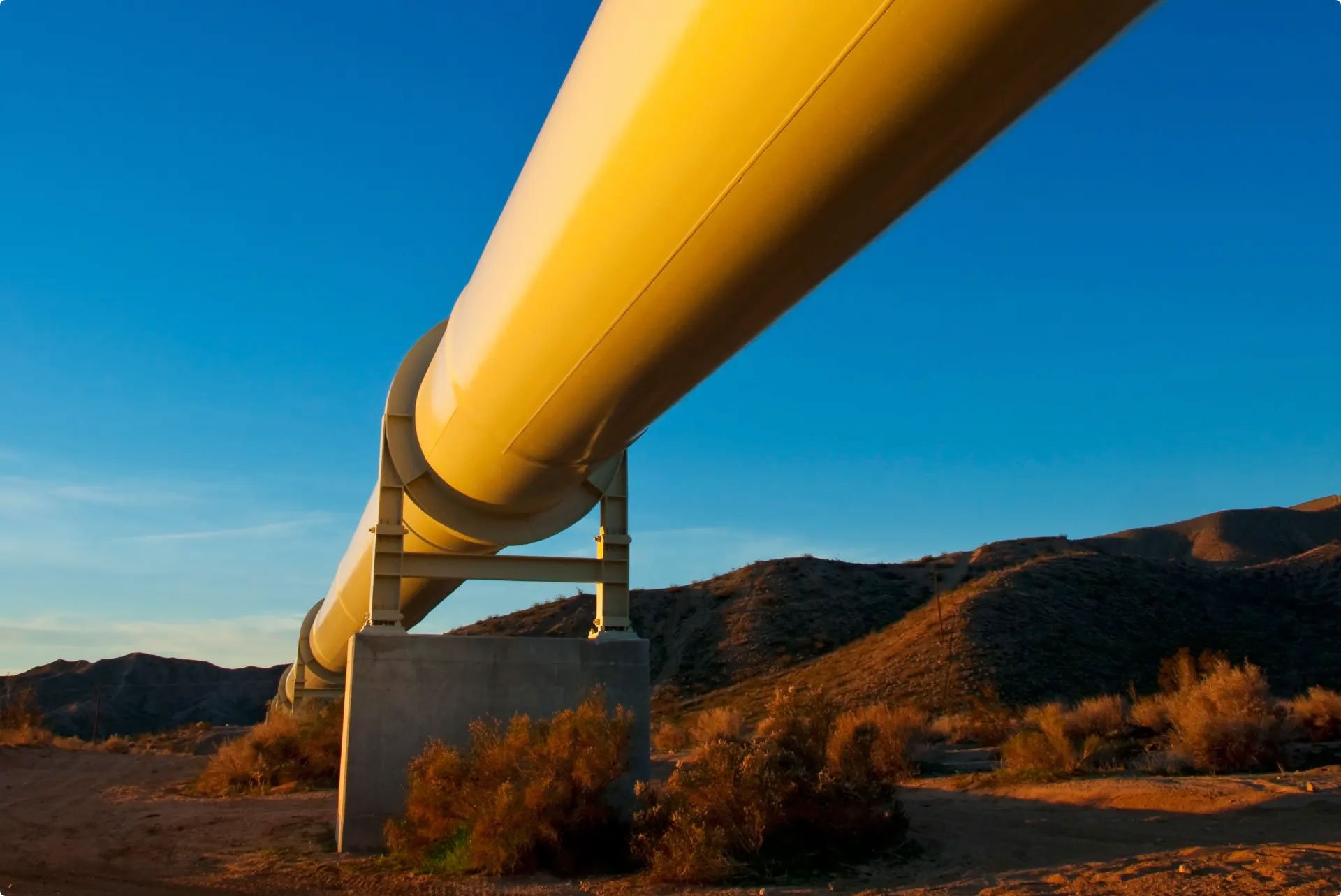yellow pipeline spanning in hills