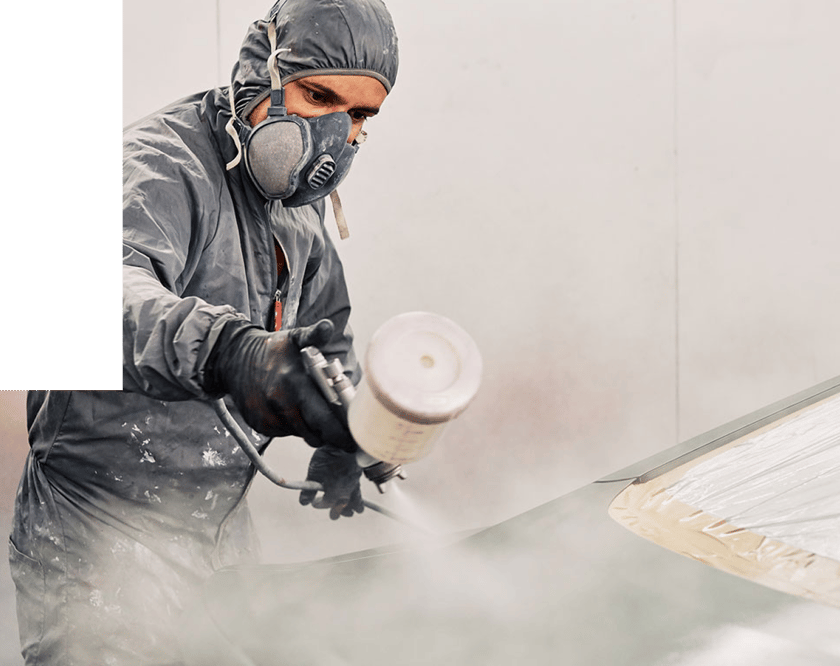 worker painting vehicle hood